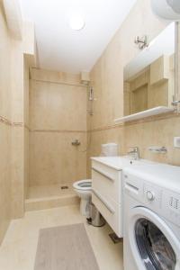 a bathroom with a washing machine and a toilet at Apartments Natasa in Sveti Stefan