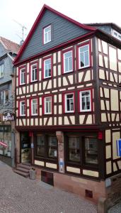 a black and white building with windows on a street at Grimmelshausen Hotel in Gelnhausen