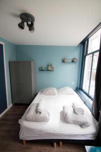 Un dormitorio con una cama blanca con toallas. en Urban Vibes Guesthouse, en Ámsterdam