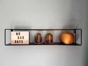 une étagère avec une citrouille orange, des bocaux et un panneau dans l'établissement Urban Vibes Guesthouse, à Amsterdam