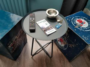 a round table with a remote control and a book at Urban Vibes Guesthouse in Amsterdam