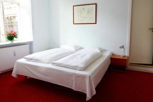 a white bed sitting in a room next to a window at Hotel Nora Copenhagen in Copenhagen