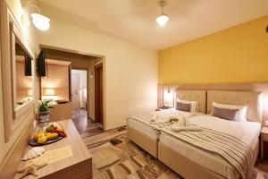 a bedroom with a bed and a bowl of fruit on a table at Thalia deco City & Beach Hotel in Hersonissos