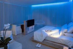 a blue room with a bed and a tv at Encanto Acapulco in Acapulco