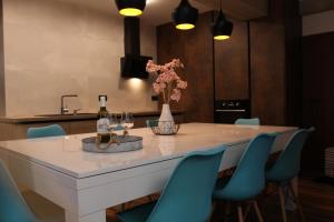 a kitchen with a table with a bottle of wine and some blue chairs at Apartmán 17 Romantika Chopok Juh Tále in Tale