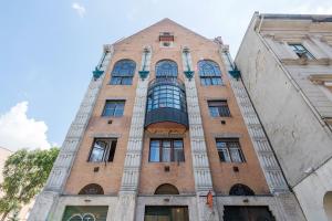 ein großes Backsteingebäude mit einem großen Fenster in der Unterkunft Industrial Style Appartment with AC steps to Gozsdu in Budapest