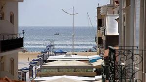 uitzicht op het strand vanaf het balkon van een gebouw bij Casa Bonequinha in Nazaré