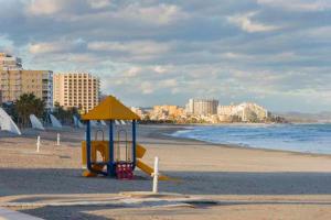 a playground on a beach next to the ocean at Apartamentos Entreplayas in Oropesa del Mar