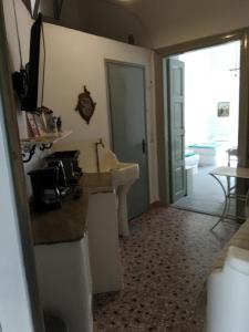 a kitchen with a counter and a sink and a door at Apano Vrysi in Tinos +23 photos