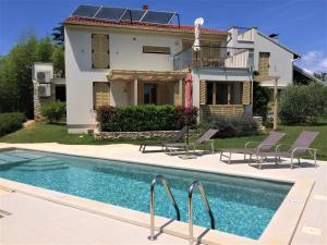 a house with a swimming pool in front of a house at Casa Bamboo in Banjole