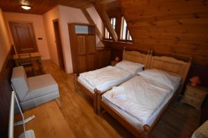 a bedroom with a bed and a chair at Horská bouda U Kokrháče in Dolní Malá Úpa
