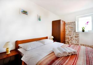 a bedroom with a bed with two towels on it at Old Town Vrsar, apartments Danica & Zoran in Vrsar