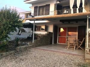 a house with a porch with a bench and a table at Casa Lugori in Torre Dei Corsari