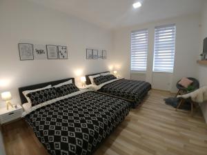 1 Schlafzimmer mit 2 Betten und 2 Fenstern in der Unterkunft Apartments Sari in Sarajevo