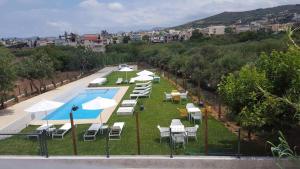 a group of chairs and umbrellas next to a pool at Kallimento in Kissamos