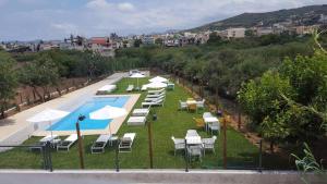 Un grupo de sillas y sombrillas junto a una piscina. en Kallimento, en Kissamos
