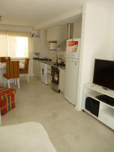 a kitchen with a refrigerator and a stove top oven at 1-1/2 AMB c/BALCON SOLEADO en EDIFICIO FRENTE AL MAR in Mar del Plata