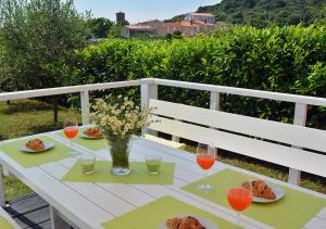 uma mesa com pratos de comida e copos de vinho em Sunset Garden House Vrsar em Vrsar