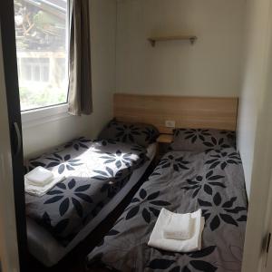 two beds in a small room with a window at Simonai Mobile Homes in Čezsoča