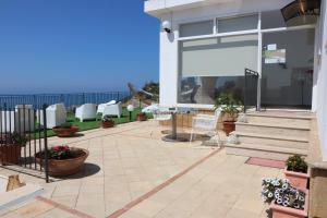 un patio con mesa, sillas y el océano en B&B Vista sul Mare, en Porto Empedocle