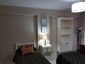 1 dormitorio con cama, lámpara y ventilador en Juventus en Córdoba