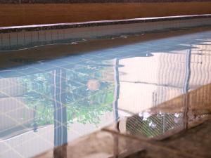 a swimming pool with a reflection of the water at Wisterian Life Club Atami in Atami