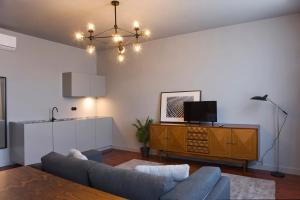 a living room with a couch and a tv at Oporto Cozy Design Studio - Solar da Avenida in Porto