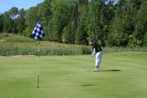 a man playing golf on a golf course at Drummond Island Resort & Conference Center in Drummond