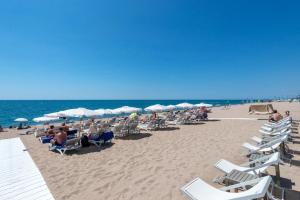 a group of chairs and umbrellas on a beach at Hotel Mar i Sol in Calella