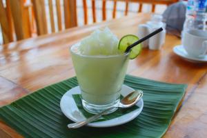 a drink with a lime on a plate on a table at The Tandjung Cottage in Nusa Penida +32 photos
