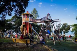 um grupo de pessoas sentadas num banco num parque em Picture Perfect Hotel Living em Auckland