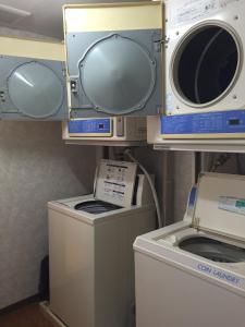 a laundry room with two microwaves and a washer and dryer at Aoi Business Hotel in Fukuyama