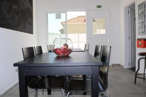 a black dining room table with a bowl of fruit on it at In My House in Castro Verde