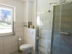 een badkamer met een toilet en een glazen douche bij Ferienwohnung Hörmann in Wittdün