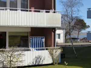 ウィトデュンにあるFerienwohnung Hörmannの白い柵と青い椅子のある家