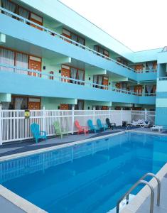 a pool in front of a hotel with chairs at Beachside Resort in Wildwood