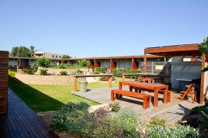 un patio trasero con una mesa de picnic y un banco de picnic en Riverside Ocean Grove, en Ocean Grove