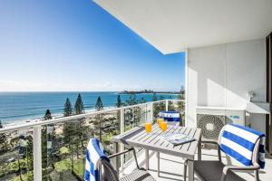 balcón con mesa, sillas y vistas al océano en Pacific Beach Resort en Mooloolaba