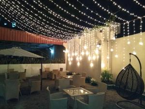 a restaurant with lights on the wall and chairs at Hotel Grand Tizu in Dimāpur