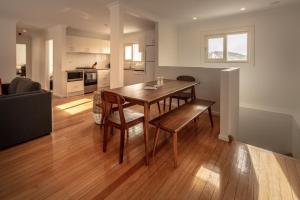 a kitchen and living room with a wooden table and chairs at Numbananga Lodge in Smiggin Holes +6 photos