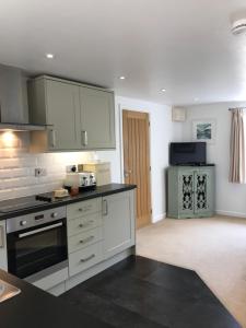 a kitchen with white cabinets and a stove top oven at Crosspark in Kingsbridge