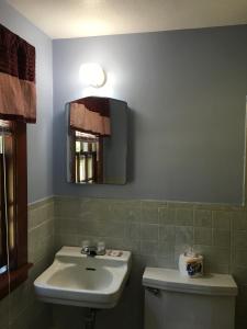 a bathroom with a sink and a toilet and a mirror at Bass River Motel in South Yarmouth