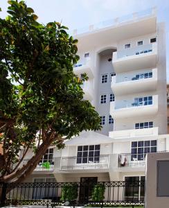 un edificio bianco con un albero di fronte di Aquarius Boutique Hotel a Rethymno