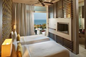 a hotel room with two beds and a television at Sentido Heritance Negombo in Negombo