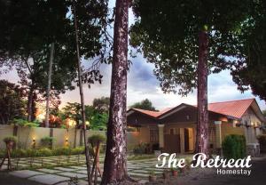 une maison avec des arbres devant elle dans l'établissement The Retreat Homestay, à Tanjung Malim