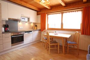 a kitchen with a table and chairs and a window at Gästeheim Anni Winkler in Nauders