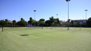 um campo de ténis com duas redes de ténis em Villetta Residence Chiusurelle em Porto Cesareo