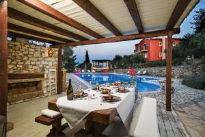 a patio with a table and a swimming pool at Bella Vista Villas & Suites in Gaios