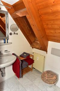 La salle de bains est pourvue d'un lavabo et d'un plafond en bois. dans l'établissement Black Forest Bollenhut Deluxe, à Lenzkirch