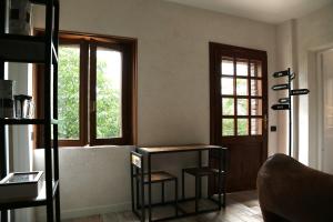 a living room with a table and two windows at LA MAESTA' in Langhirano